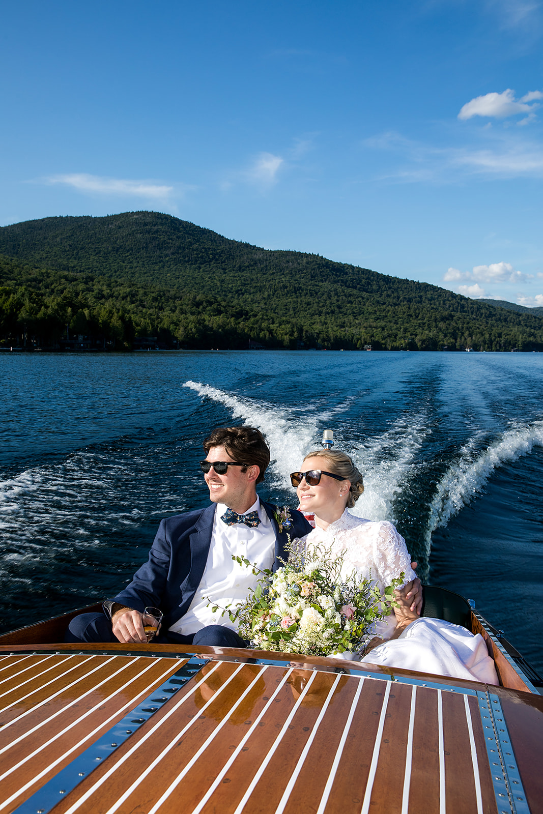 Newlyweds on a boat ride on Lake Placid, form a wedding at the Whiteface Golf Club Lake Placid