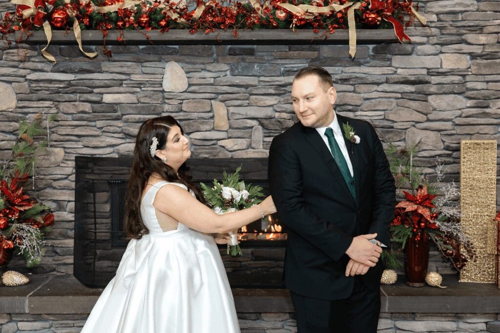 Bride and grooms first look before the ceremony in front of a stone fireplace at hall of springs saratoga ny.
