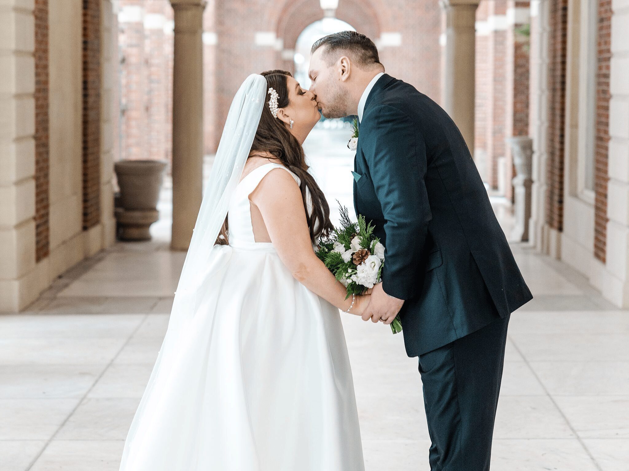 Bride and Groom posing after their wedding kissing.